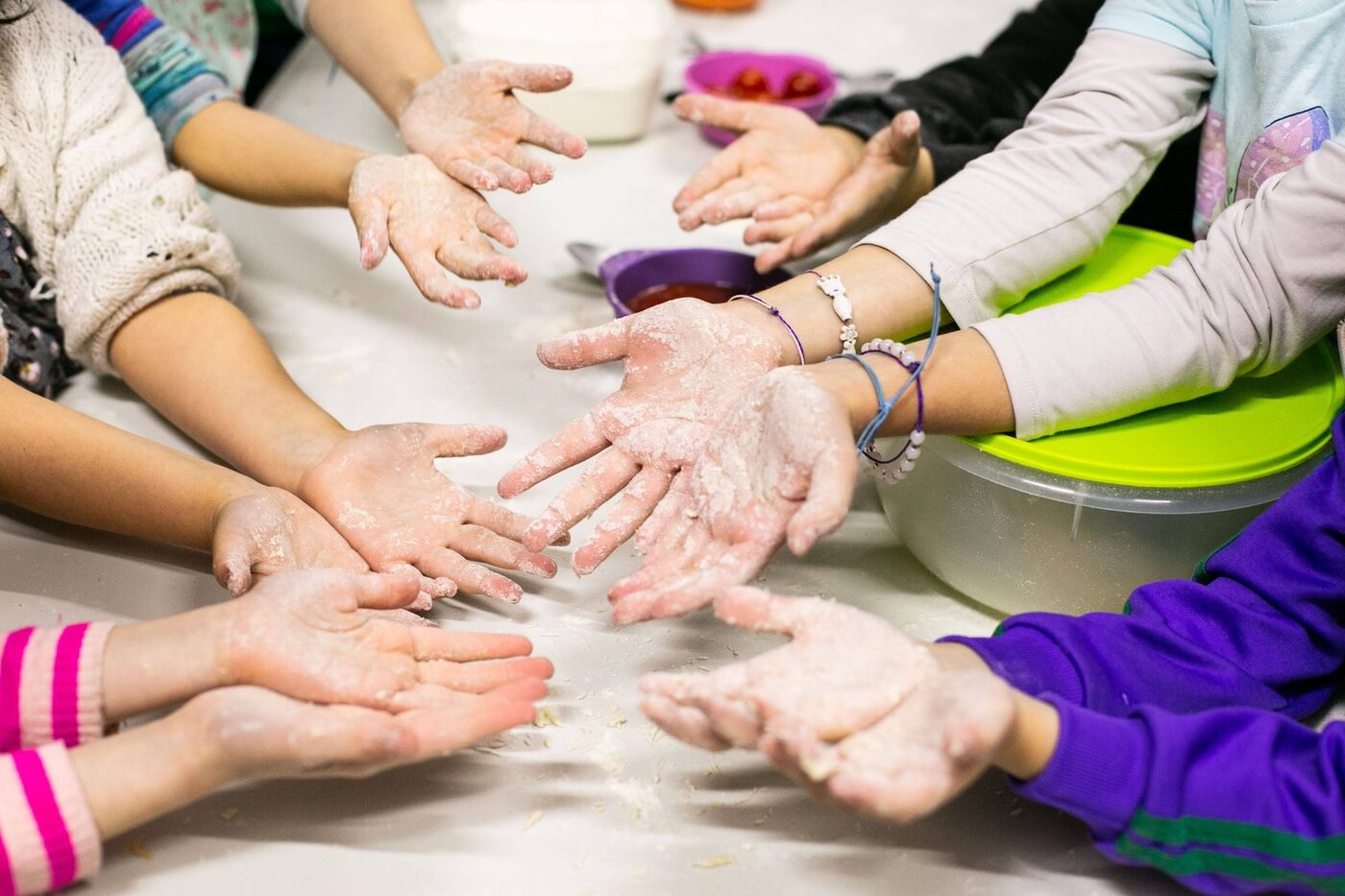 Chicos y chicas cocinando con las manos enharinadas en Taller Garbanzo